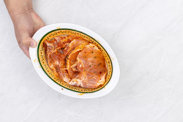 Raw pork chops marinated and prepared for barbecue grill with copy space