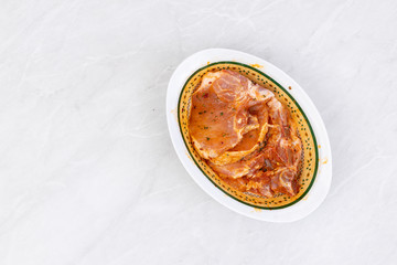 Raw pork chops marinated and prepared for barbecue grill with copy space