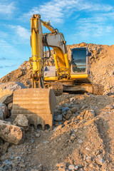 Obraz premium Construction site with an excavator moving roc