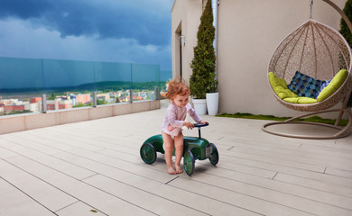 happy baby girl playing on the patio before the storm