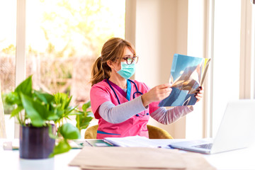 Female doctor working at doctor's office and checking up x-ray image