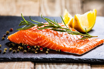 Fresh raw salmon steak on black stone board
