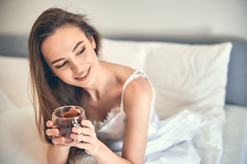 Caucasian happy woman having rest and holding cup in arms