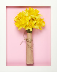 Bouquet of yellow spring flowers. Bunch narcissus packed craft paper. Spring card for Mother's Day and Easter