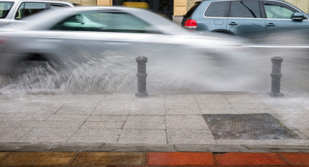 Car crossing a puddle and splashing water