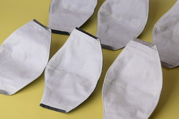 cloth mask material with white salu muslin fabric soft textile, group of objects put on yellow...