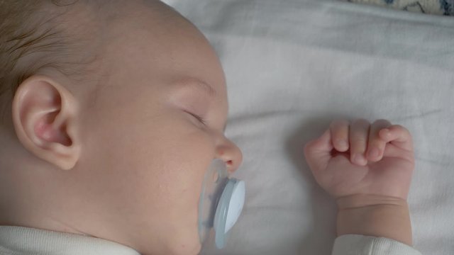 Close Up Of A Sleeping Baby Sucking A Pacifier