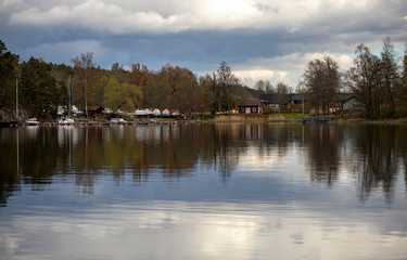 
Boat station and lakeside houses under a cloudy spring sky