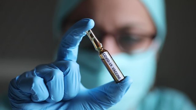 Conceptual dolly video of a doctor holding a recipient with the coronavirus COVID-19 vaccine.