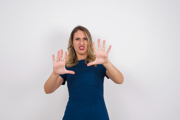Dissatisfied female model frowns face, has disgusting expression, shows tongue, expresses non...
