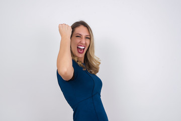 Fototapeta na wymiar Overjoyed happy excited blonde female glad to receive good news, gestures actively from happiness, clenching fist and making winning gesture. Reaction concept.