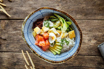 Poke bowl rice vegetables salmon end quail eggs