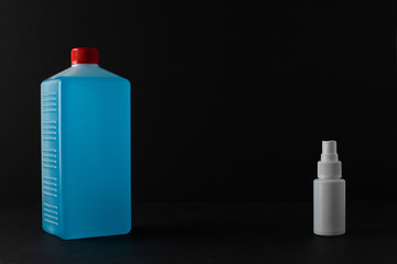 Bottle of antiseptic on black background. Antibacterial spray for hands. Plastic bottle of...