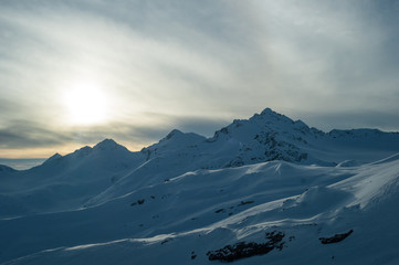 Fototapeta na wymiar sunset on top of snowy mountains