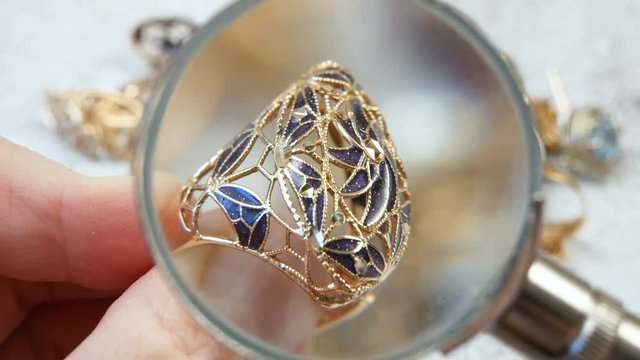 jeweler looking at jewelry through magnifying glass, jewerly inspect and verify, pawnshop concept, jewerly shop concept