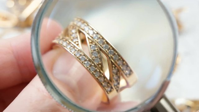 jeweler looking at jewelry through magnifying glass, jewerly inspect and verify, pawnshop concept, jewerly shop concept