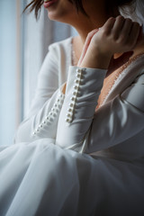 White buttons on a girl sleeve, wedding dress, deep neckline