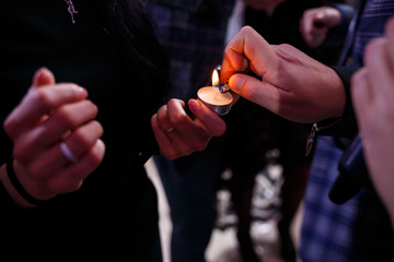 Burning candle in the hands of the newlyweds