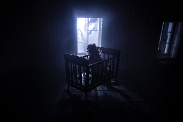 Old creepy eerie baby crib near window in dark room. Scary baby silhouette in dark. A realistic...