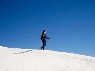 Woman snowshoeing in San Isidro, León, Spain on a sunny day. Blue sky. White snow. Women's empowerment. Female power