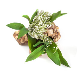 Bouquet of lily of valley is placed in bast like as in vase isolated on white