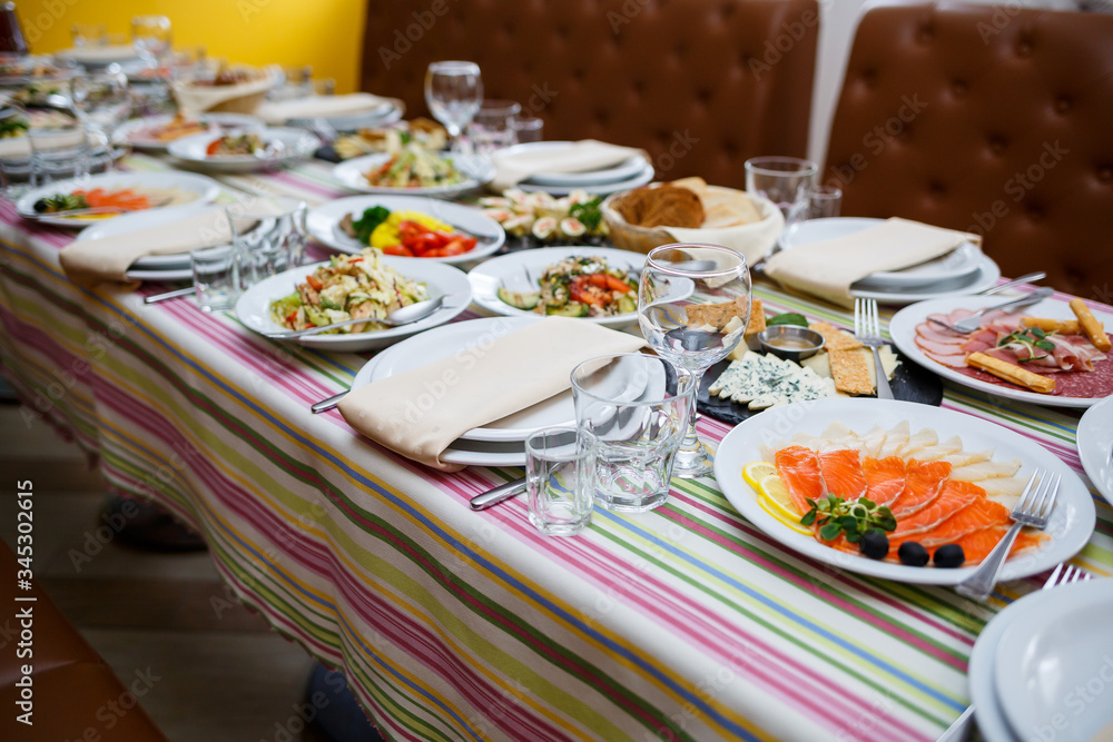 Wall mural table in the restaurant, dishes in white plates, festive banquet