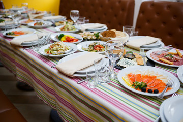 Table in the restaurant, dishes in white plates, festive banquet