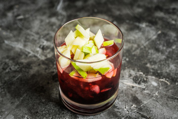 Old fashioned cocktail with blackberry liqueur and apple slices on rustic background. Selective focus. Shallow depth of field.