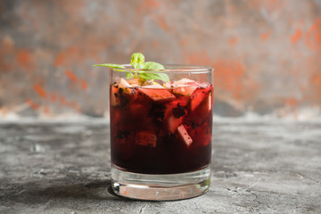 Old fashioned cocktail with blackberry liqueur and apple slices on rustic background. Selective focus. Shallow depth of field.