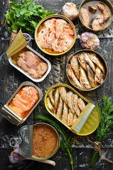 Salmon, tuna, mackerel and sprats - Canned fish in tin cans. Top view. Free space for your text.