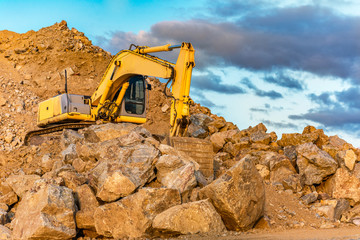 Obraz premium Construction site with an excavator moving roc