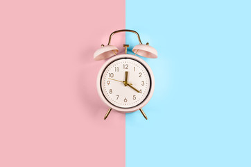 Ringing twin bell vintage classic alarm clock Isolated on blue and pink pastel colorful trendy...