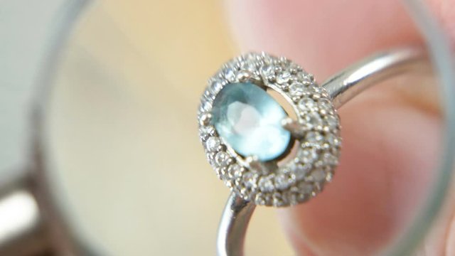 jeweler looking at jewelry through magnifying glass, jewerly inspect and verify, pawnshop concept, jewerly shop concept