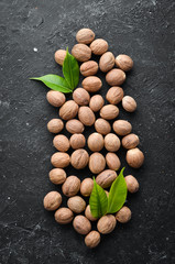 Whole nutmeg on black stone background. Spices. Free space for your text. Top view.