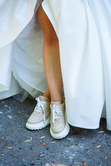 Bride in a white dress and sneakers on a wedding day