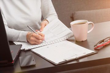 top view , a girl works on a laptop and writes data in a table. manager work concept.