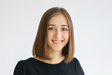 Portrait of a happy cute woman in a black dress on a white background smiling