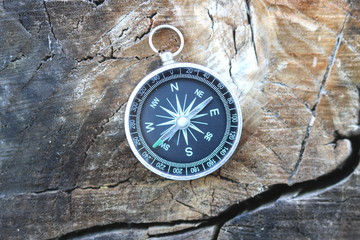 Old compass on natural wooden background