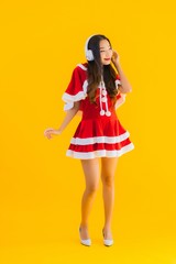 Portrait beautiful young asian christmas clothes and hat listen for music