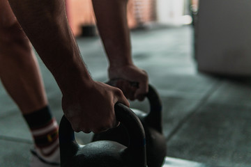 Close up of a young muscle athlete holding weights and preparing to lift