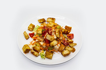 Salad with meat of pig, tomatoes, carrots, cabbage and crackers with bread runner with sauce on the white plate. Healthy and tasty meal for the diet. Delicious breakfast or lunch without GMO