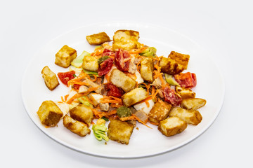 Salad with meat of pig, tomatoes, carrots, cabbage and crackers with bread runner with sauce on the white plate. Healthy and tasty meal for the diet. Delicious breakfast or lunch without GMO