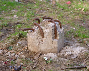 Sticking out of the ground a piece of a concrete pillar with the bent valves
