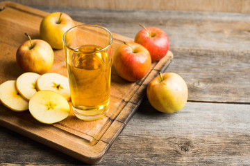Apple juice with freshly harvested apples on the rustic background. Selective focus. Shallow depth of field.