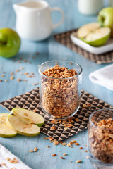 homemade classic granola in a glass with apples on a light background