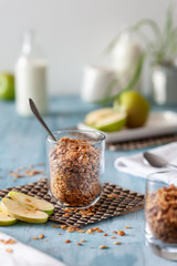 homemade classic granola in a glass with apples on a light background
