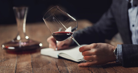 Sommeliers male hold glass red wine tasting degustation card - obrazy, fototapety, plakaty
