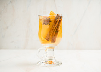 Healthy hot beverage with oranges, apples and spices for protection in flu season. Selective focus. Shallow depth of field.