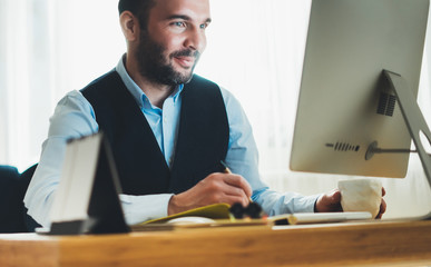 Fototapeta premium smile businessman looking in monitor computer at home workplace, man working at social distance, freelancer online communication work process, online education