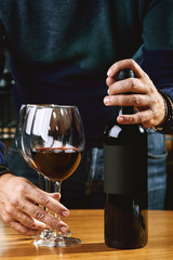 Sommelier hands in the frame offer and pour wine into a glass. Winemaking, the culture of drinking wine.